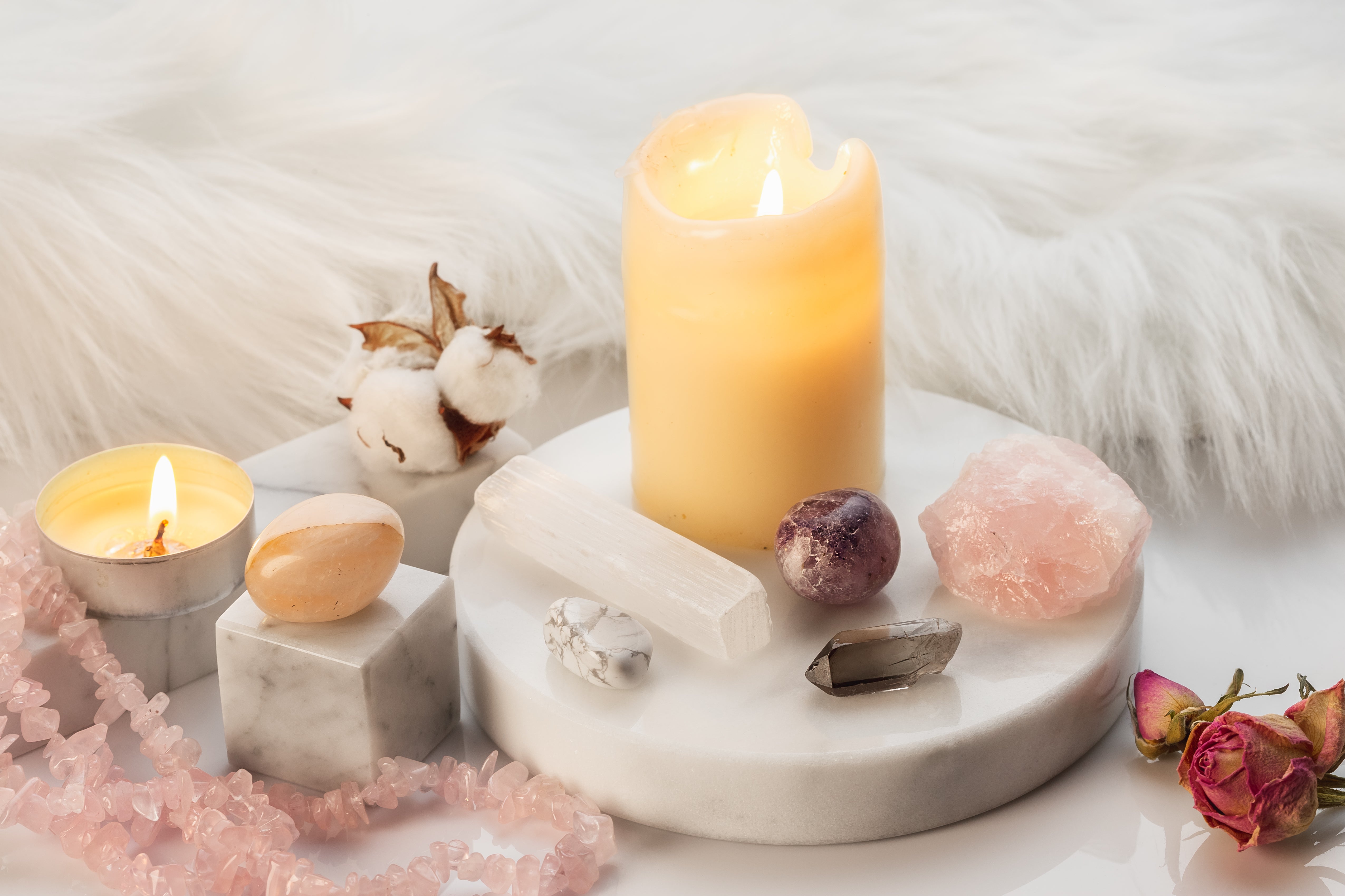 raw selenite with a candle and other stones